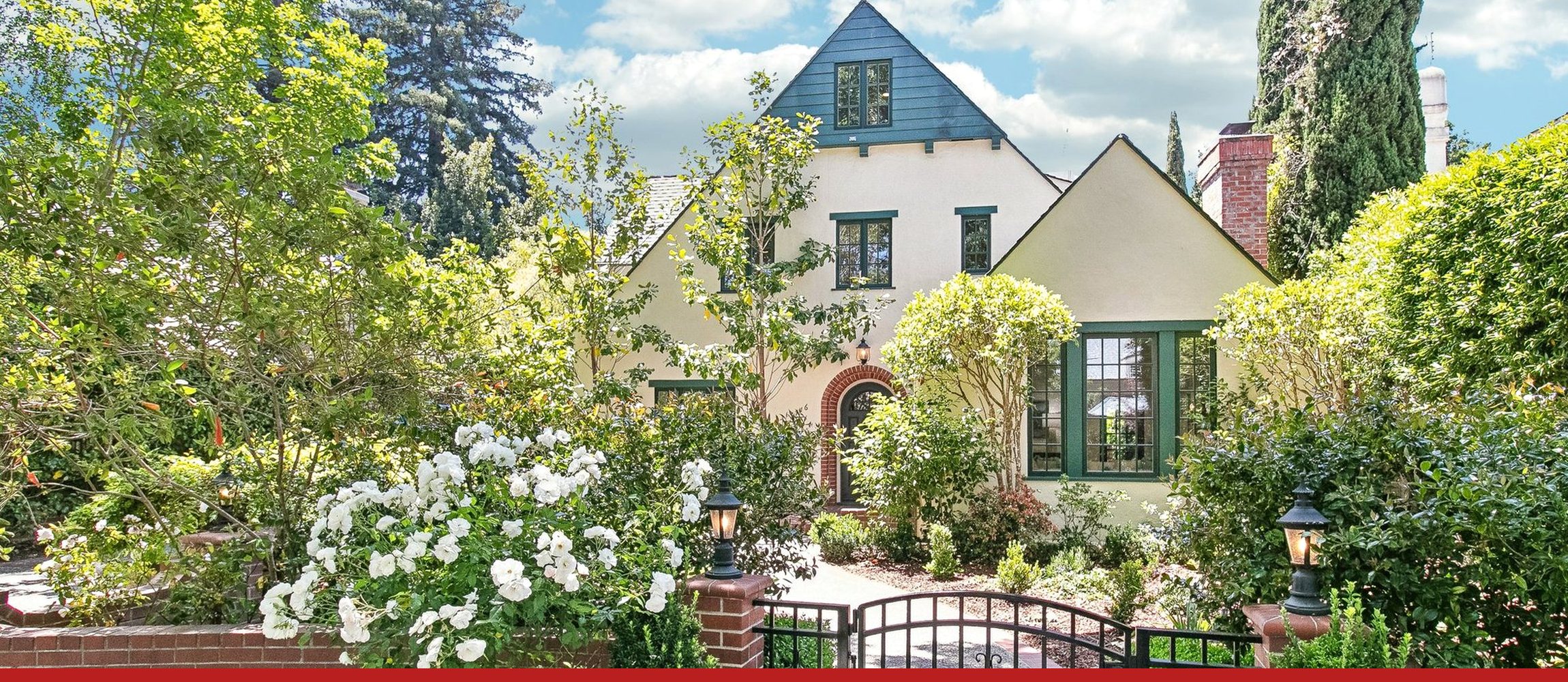 A Palo Alto house on Fulton Street behind its rose garden and brick wall, on a clear day