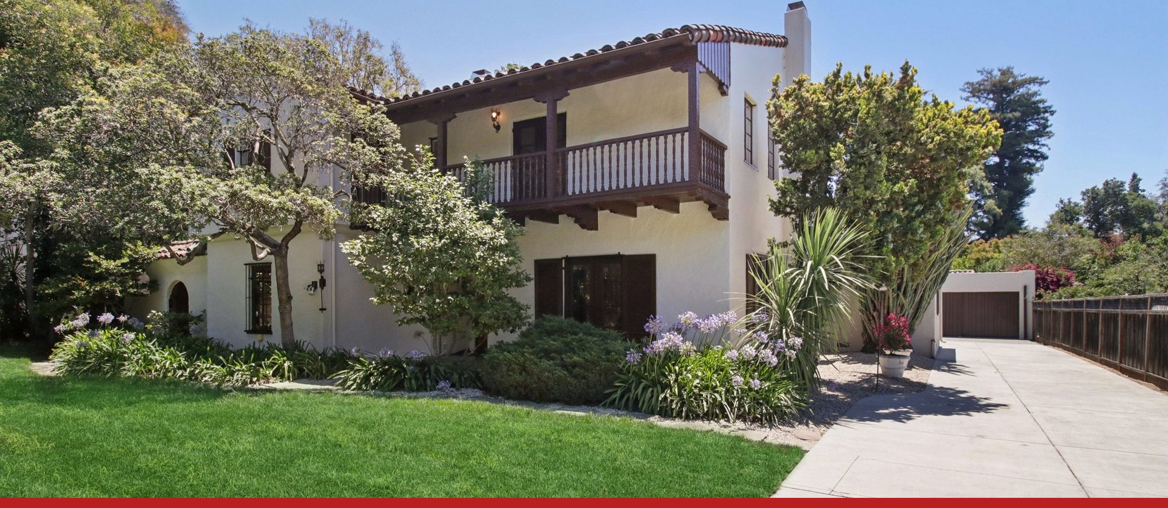 A Spanish-style Palo Alto house on University Avenue, seen from its lawn on a clear day