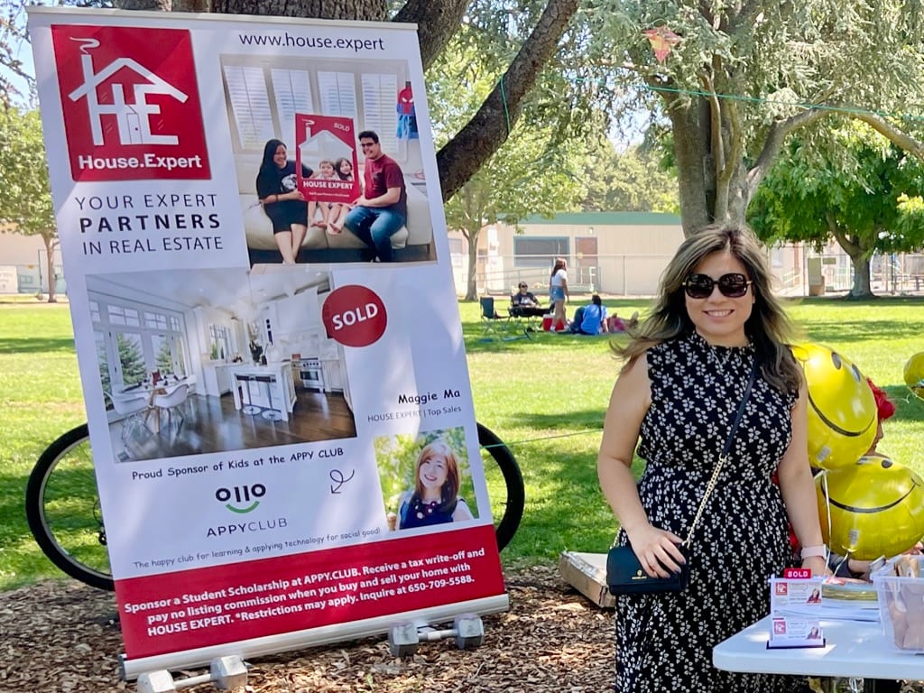 Maggie Ma beside the House.Expert banner at an APPY CLUB event in a Palo Alto park