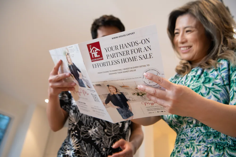 Maggie holding open the seller brochure that lists what the fee covers