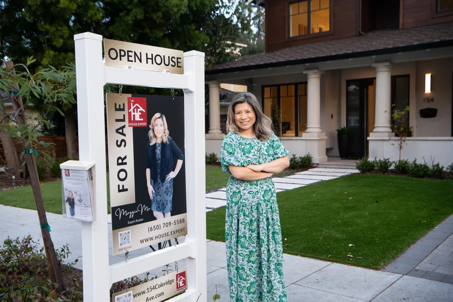 Maggie beside the House Expert For Sale sign outside a listing on the day it went live