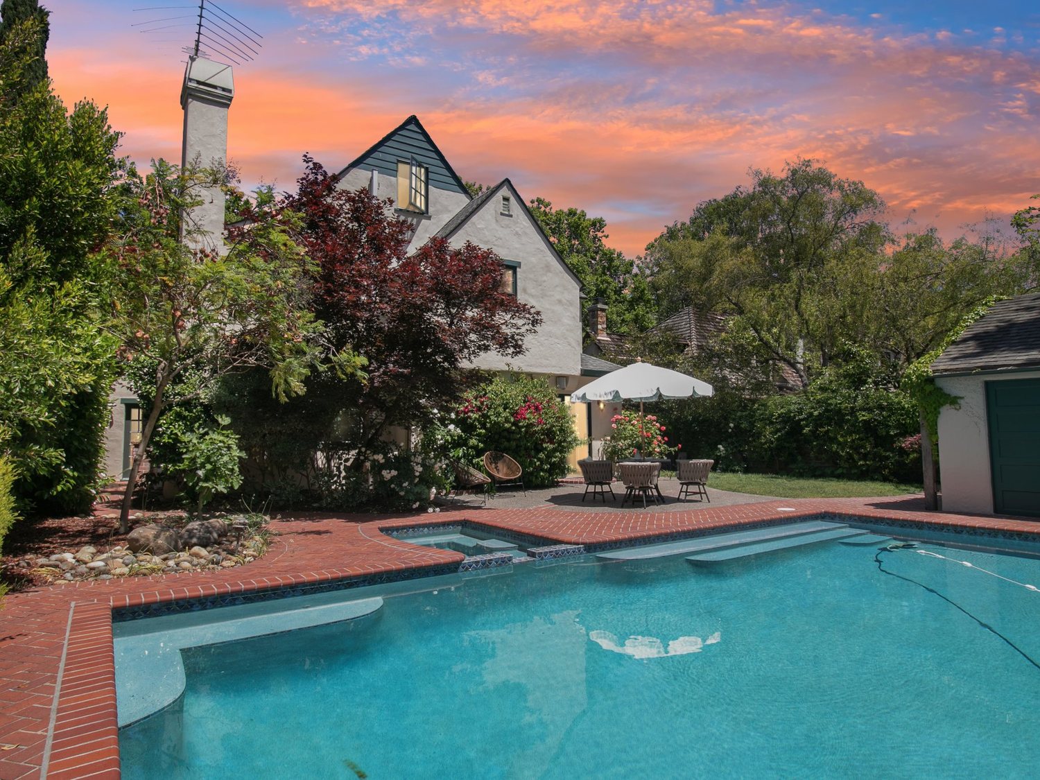 The pool and brick terrace at 1716 Fulton Street photographed at dusk