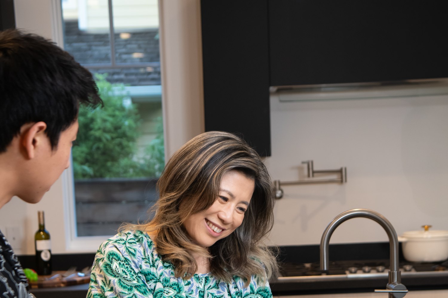 Maggie Ma at a kitchen counter with two clients, going through a marketing piece page by page